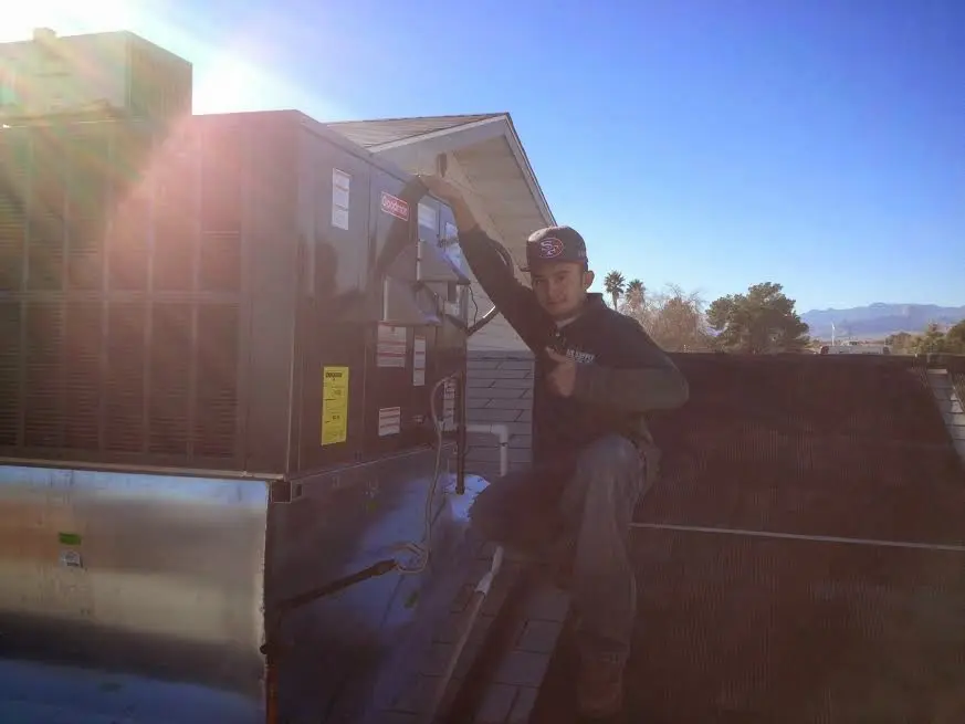 HVAC technician performing AC Tune-Up on a rooftop unit in Spring Lake Park